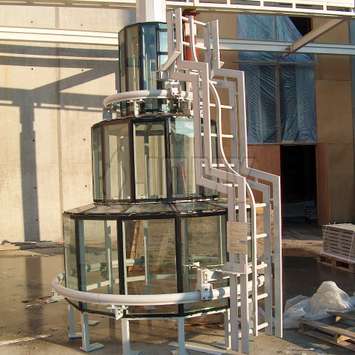 Escalera especial sobre/bajo rieles equipado con sistema de protección contra caídas, utilizada para la limpieza y el mantenimiento de una estructura de vidrio redondeada. Escalera especial sobre/bajo rieles - Unidad de mantenimiento de edificios